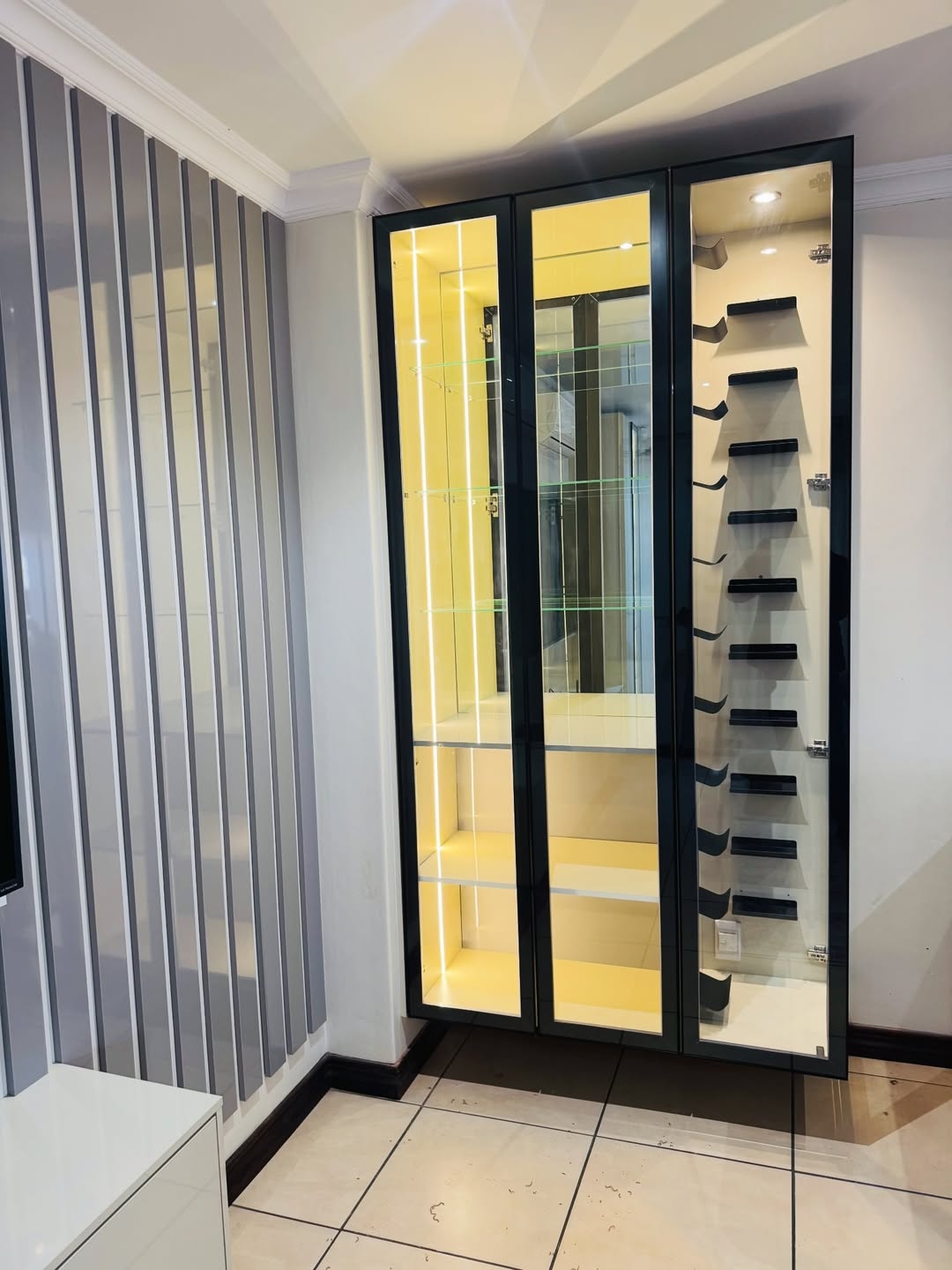 Backlit glass cabinetry with bespoke shelving